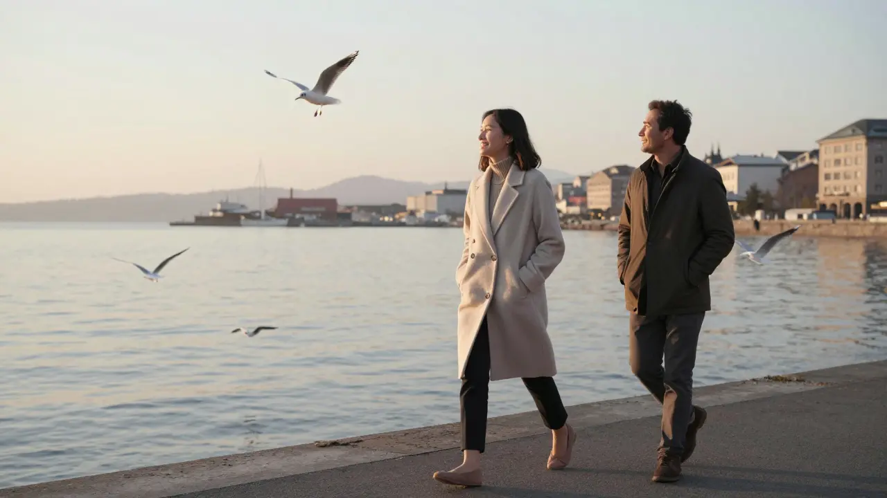 A model and man walking peacefully along a harbor at dawn, enjoying a calm, unscripted moment together.